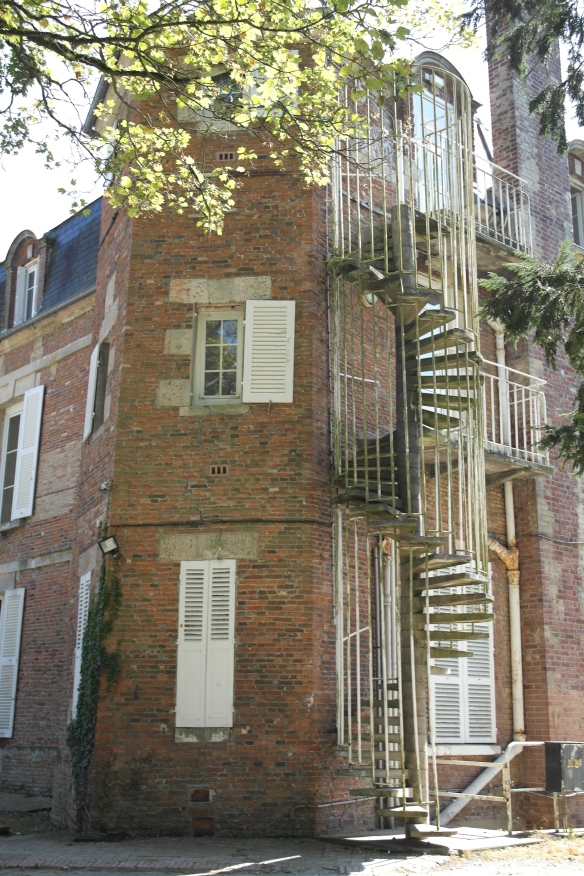 An exterior spiral stairway around the back of one of the chateau's two turrets.